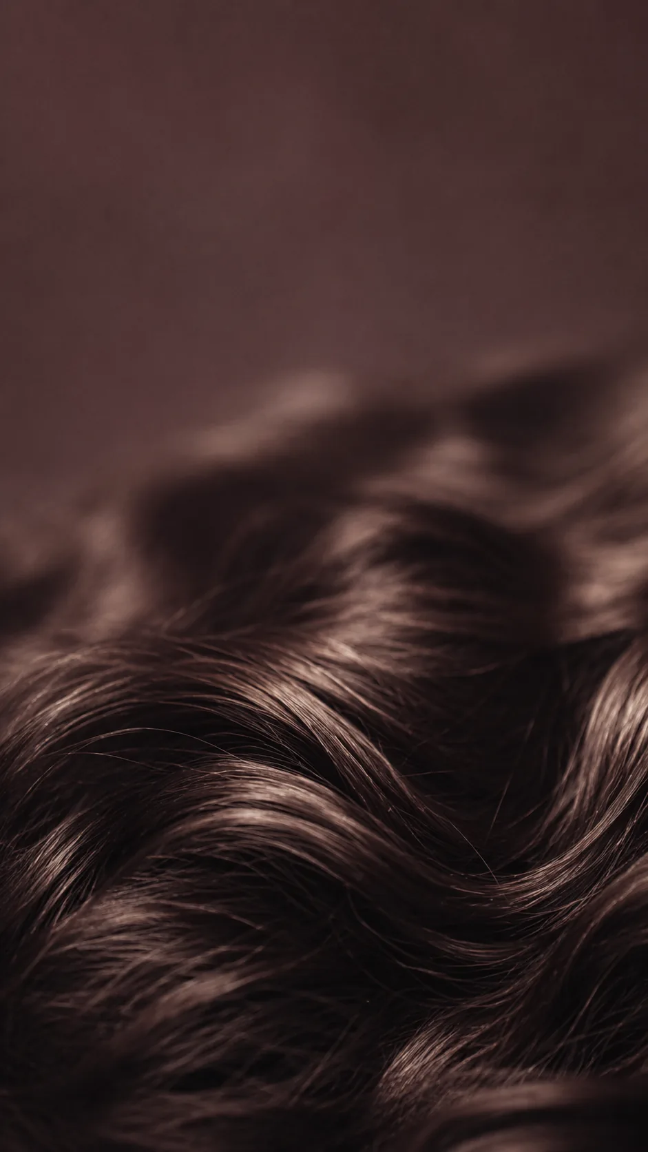 A close-up of long hair threaded with fine strands of shimmering tinsel.